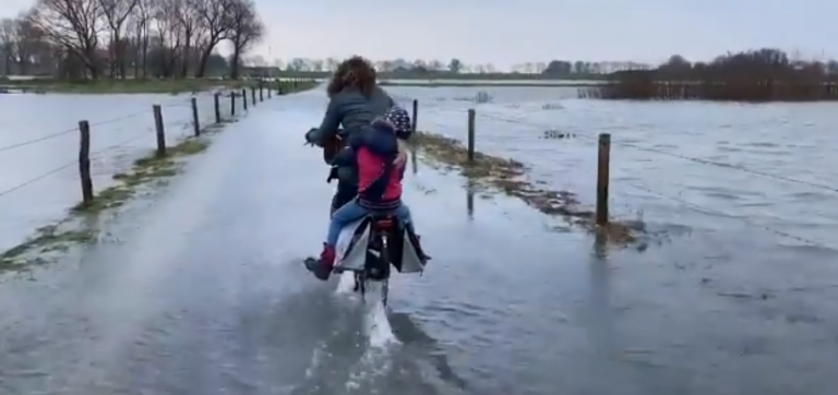 Hoogwaterfietsende moeder in Zalk gaat viraal