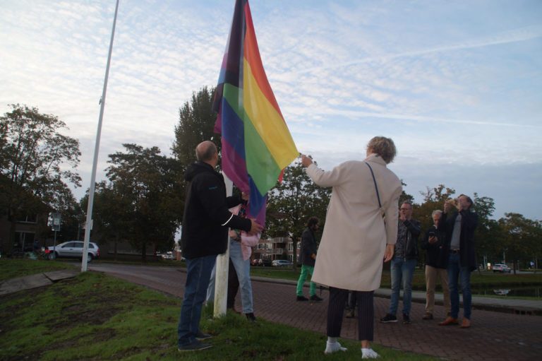 Regenboogvlag wappert Bij het Stadhuis tijdens Coming Out Day